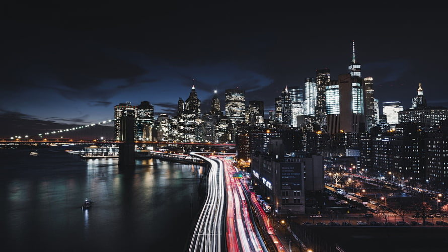 New York City Manhattan Skyline at Night with Brooklyn Bridge and Long Exposure Traffic Trails HD wallpaper