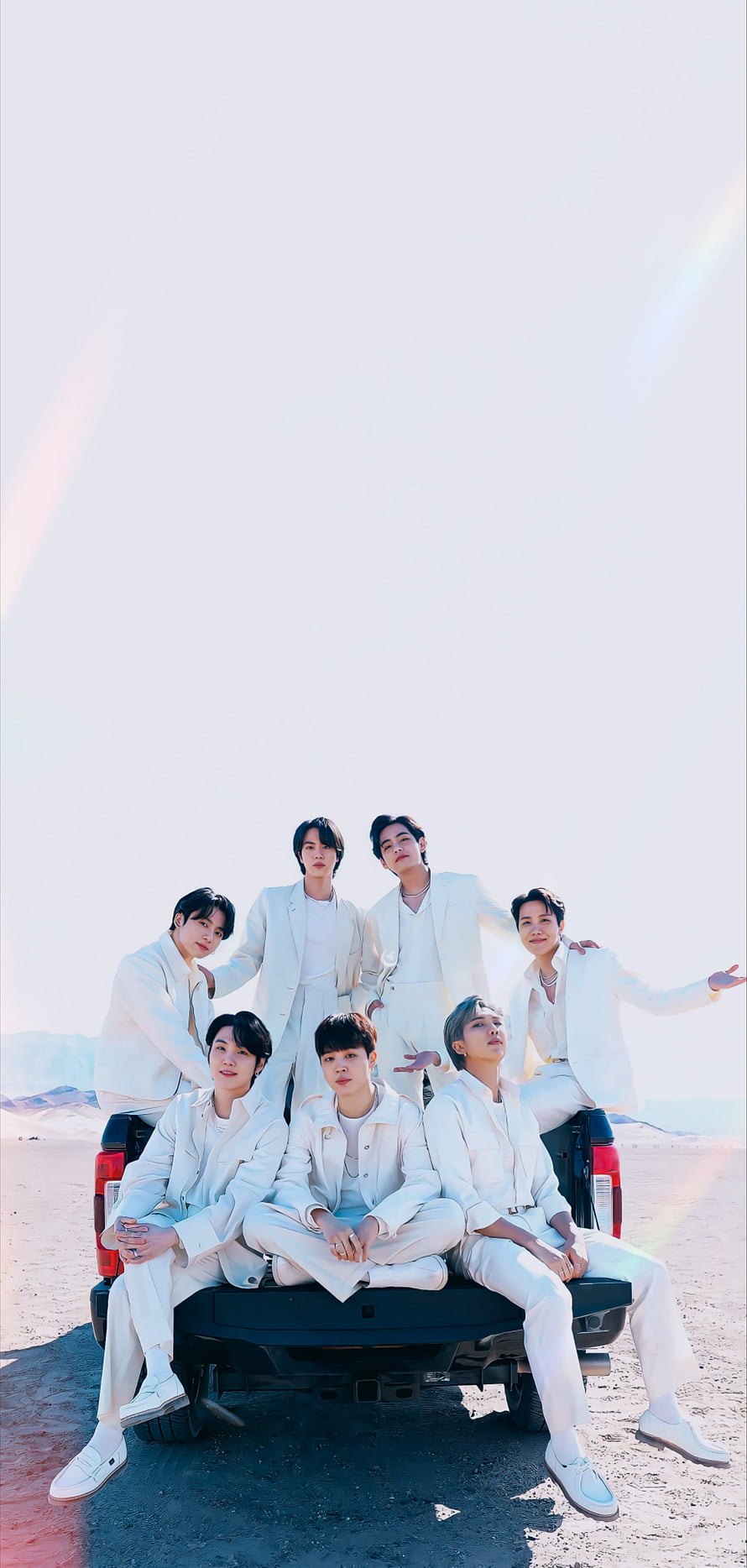 BTS members in white suits posing on a truck in the desert HD phone wallpaper