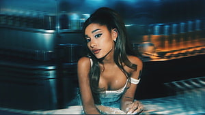 Ariana Grande in a moody blue-toned portrait with dramatic lighting and a blurred industrial background HD wallpaper