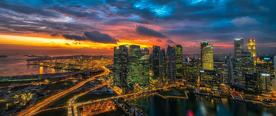 Panoramic View of Singapore Skyline at Sunset with Vibrant Clouds and City Lights HD wallpaper