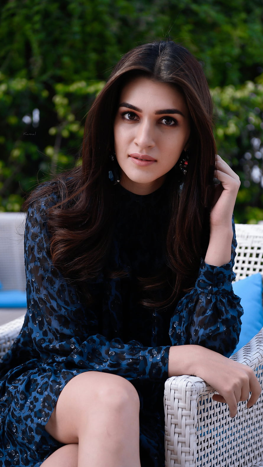 Kriti Sanon in a dark blue sequined dress seated on a white wicker chair outdoors HD phone wallpaper