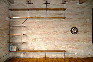 Industrial Loft Interior With Exposed Brick Wall, Pipe Shelving, and Dartboard HD wallpaper
