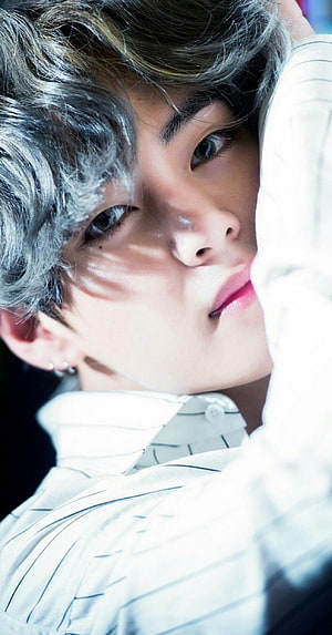 V from BTS in a white striped shirt with silver hair and a soft gaze HD phone wallpaper