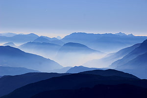 Layered Mountain Ranges Shrouded in Soft Morning Mist and Haze HD wallpaper