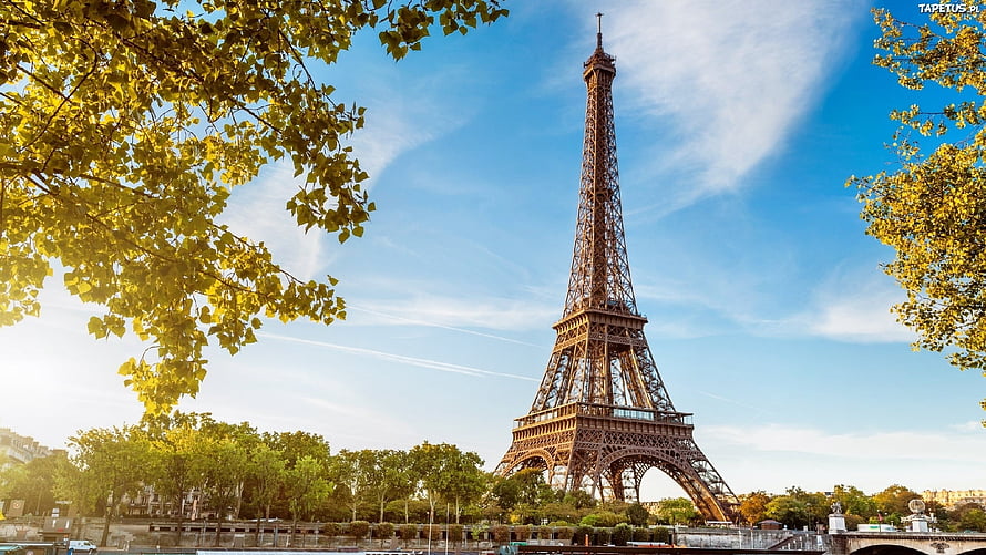 Eiffel Tower in Paris framed by golden autumn foliage under a bright blue sky HD wallpaper
