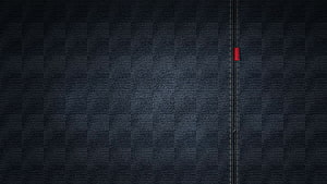 Dark Textured Fabric Surface With Vertical Stitching And Red Accent Detail HD wallpaper