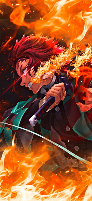 Rengoku Kyojuro from Demon Slayer wielding his flaming Nichirin sword in a dynamic battle pose surrounded by intense fire HD phone wallpaper