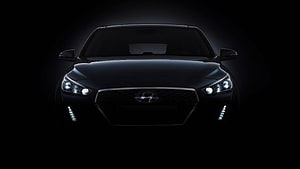 Front View of a Black Hyundai Sedan with Illuminated Headlights in Dark Atmosphere HD wallpaper