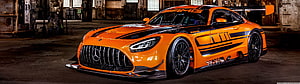 Orange Mercedes-AMG GT3 Race Car in Industrial Garage Setting HD wallpaper