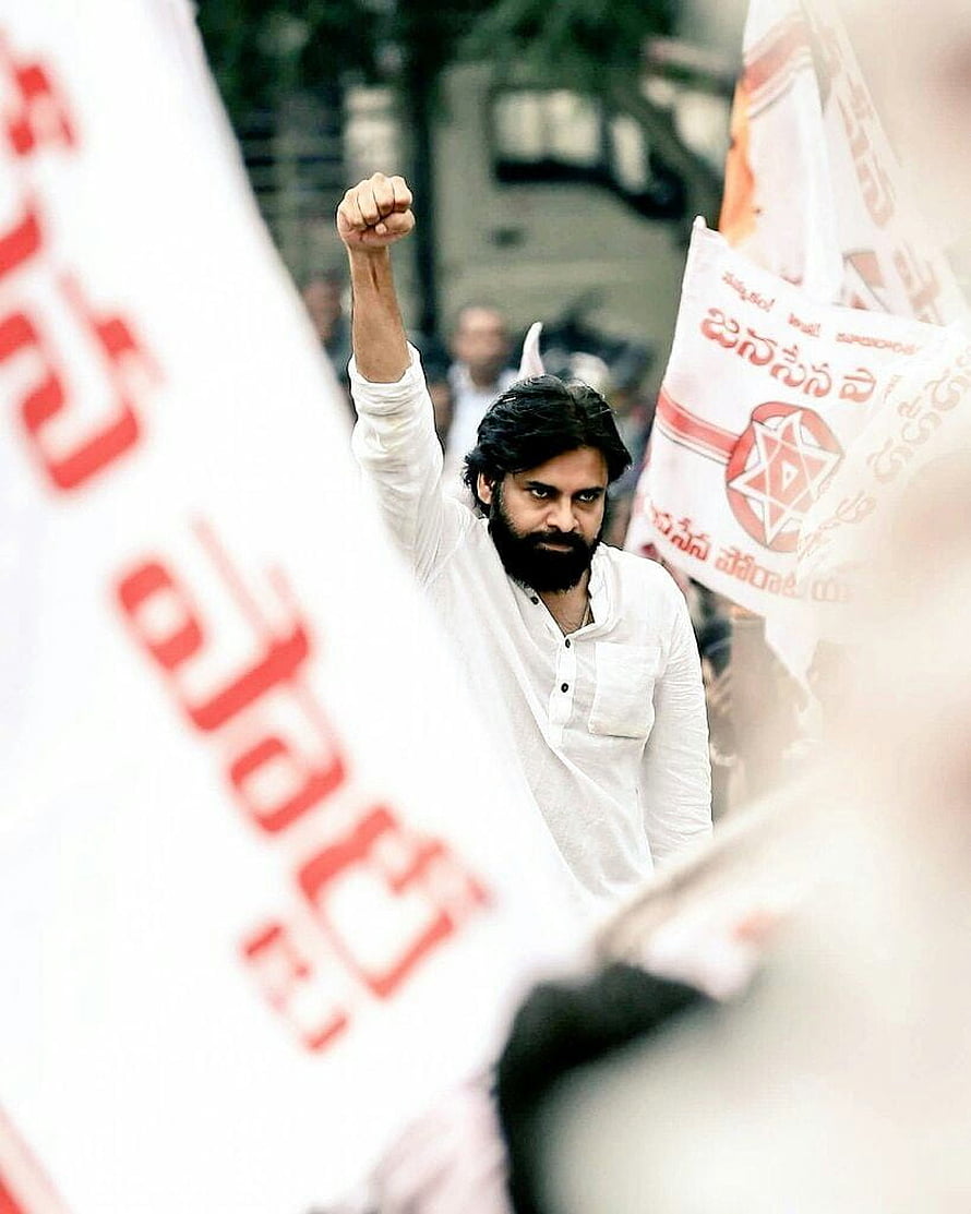 Pawan Kalyan raising fist in white kurta during political rally with flags HD phone wallpaper