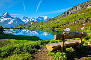 Scenic Alpine Lake with Wooden Bench and Snow-Capped Mountains HD wallpaper
