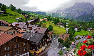 Alpine Village in Switzerland with Traditional Chalets and Mountain Backdrop HD wallpaper