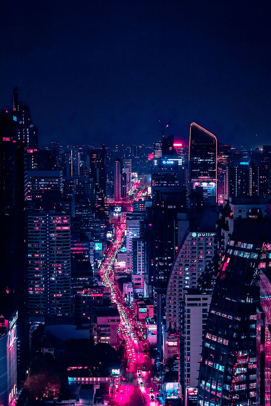 Neon-lit Bangkok skyline at night with vibrant pink and blue city lights reflecting off skyscrapers and busy streets HD phone wallpaper