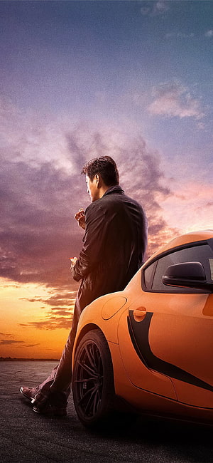 Han Lue Leaning Against Orange Supercar at Sunset in Fast and Furious 9 HD phone wallpaper