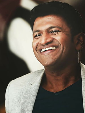 Puneeth Rajkumar Smiling Portrait in Light Grey Blazer and Black Shirt HD phone wallpaper