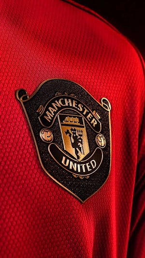 Manchester United Crest Close-Up on Red Jersey Fabric HD phone wallpaper