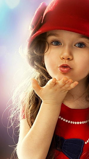 Cute Little Girl in Red Hat Blowing a Kiss with Bright Blue Eyes HD phone wallpaper