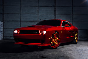 Red Dodge Challenger SRT Hellcat with Custom Yellow Rims in a Dark Garage HD wallpaper