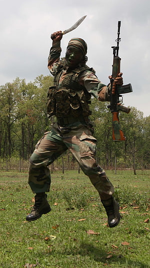 Indian Army Gorkha Soldier in Camouflage Holding Kukri and Rifle in a Forest Clearing HD phone wallpaper