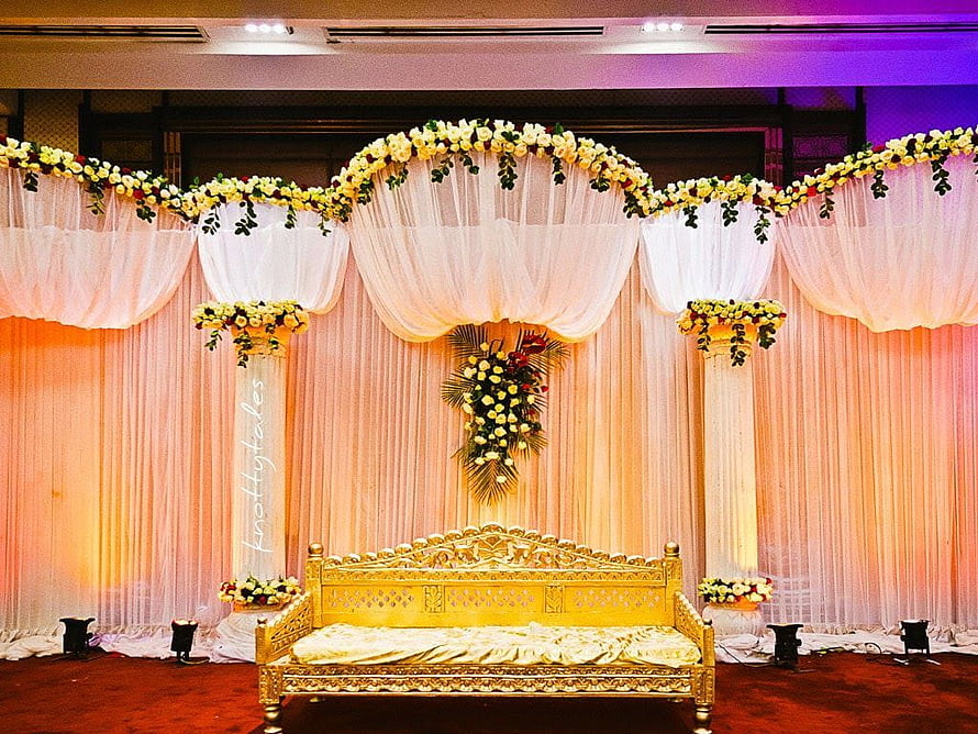 Elegant Indian wedding stage with ornate golden sofa and floral arch backdrop HD wallpaper