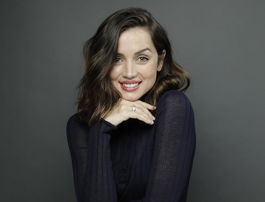 Ana de Armas smiling portrait in dark blouse against grey studio background HD wallpaper