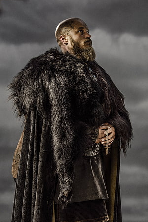 Vikings Series Character in Fur Cloak and Chainmail Against Stormy Sky HD phone wallpaper