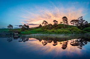 The Shire Hobbiton Movie Set at Sunset with Lake Reflection HD wallpaper