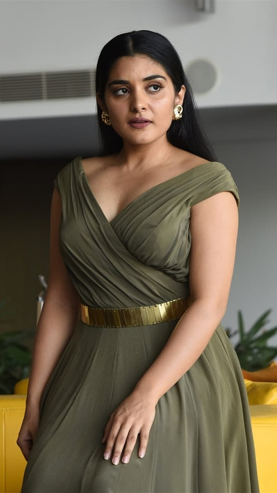 Nivetha Thomas in an elegant olive green draped gown with a gold metallic belt HD phone wallpaper