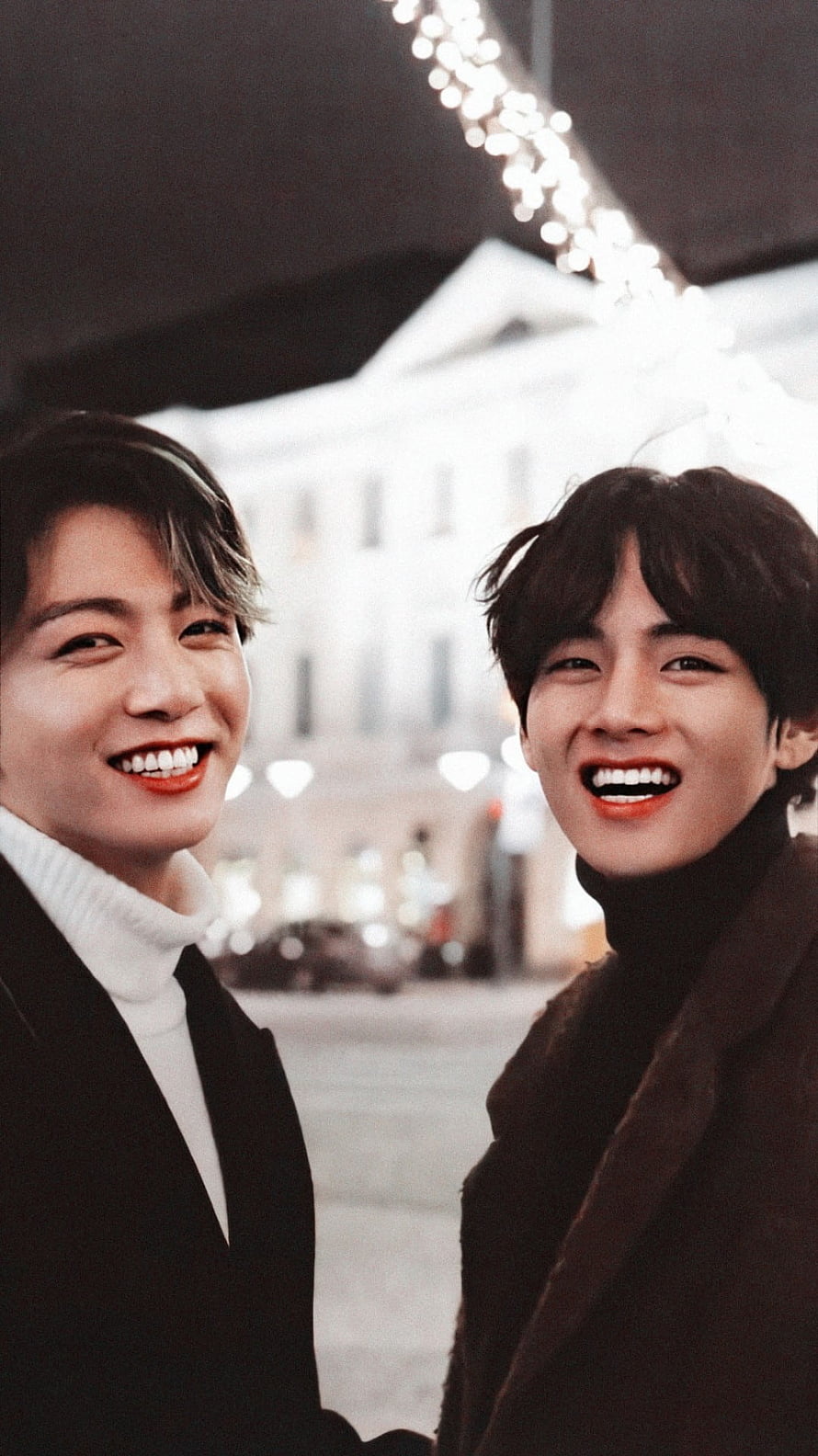 BTS V and Jungkook smiling together in winter coats with city lights background HD phone wallpaper