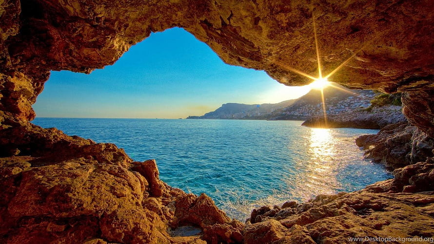 Sunset View From A Rocky Sea Cave Looking Out At The Ocean And Distant Coastline HD wallpaper