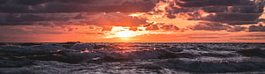Vibrant Orange Sunrise Over Churning Ocean Waves With Dramatic Clouds HD wallpaper