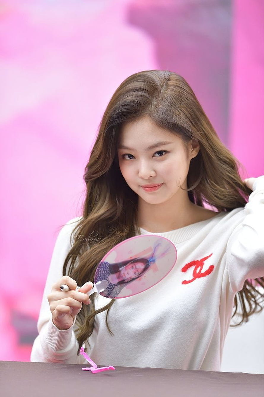 Jennie Kim from Blackpink holding a pink fan at a fan signing event wearing a white sweater HD phone wallpaper