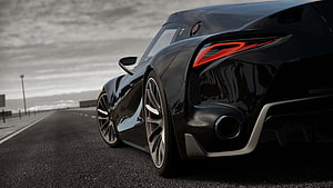 Sleek Black Supercar Rear View on Open Road with Dramatic Lighting HD wallpaper