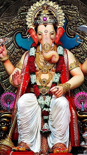 Lord Ganesha Seated Statue Adorned With Floral Garlands And Gold Jewelry HD phone wallpaper