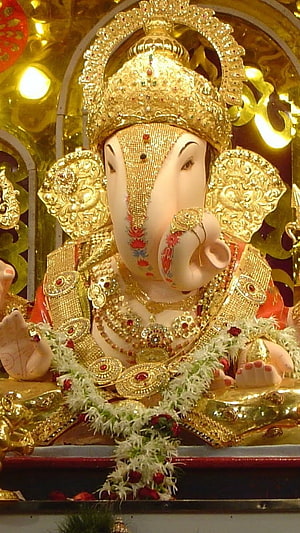 Golden Ganesha Idol Adorned With Jewels And Floral Garlands HD phone wallpaper