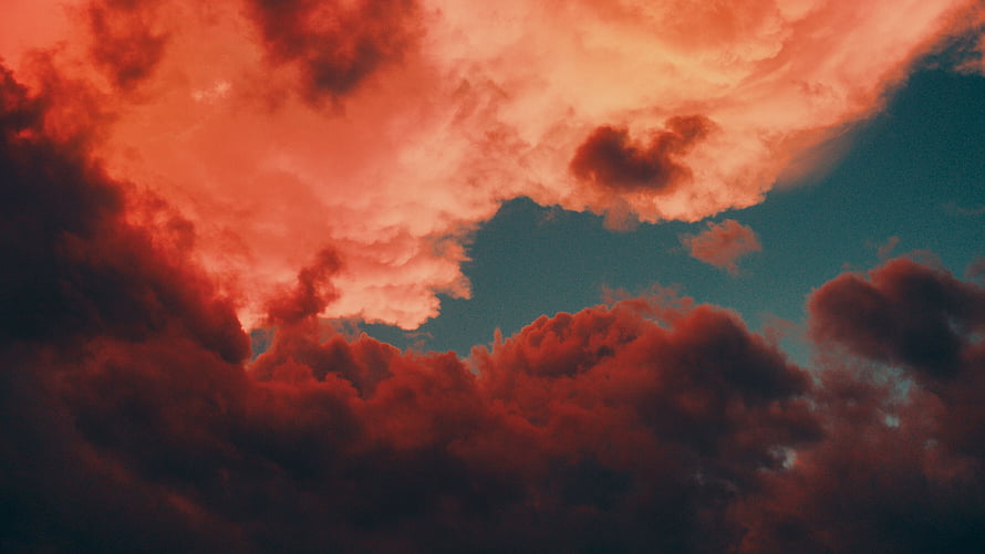 Dramatic Red and Orange Clouds Against a Deep Blue Sky HD wallpaper