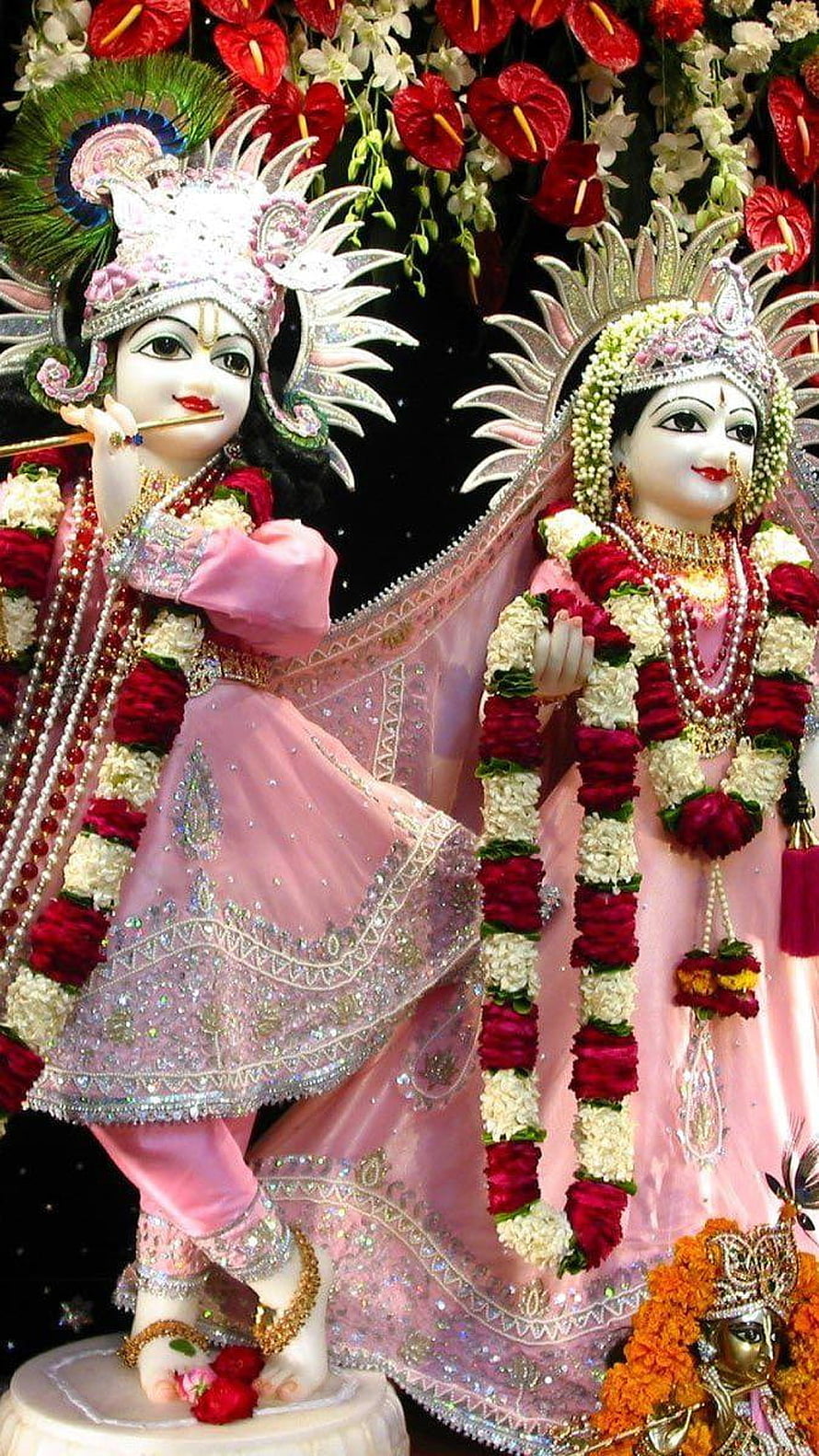 Radha Krishna idols adorned in pink silk and floral garlands for Durga Puja celebration HD phone wallpaper