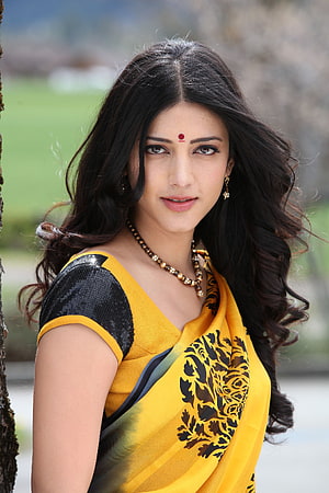 Shruti Hassan in a yellow and black floral sari with traditional jewelry HD phone wallpaper