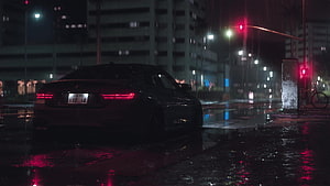 Dark BMW M8 Competition parked on a rainy city street at night with neon reflections HD wallpaper
