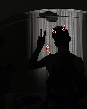 Silhouette of a person making a peace sign with red neon devil horns and arrow doodles in a dark room HD phone wallpaper