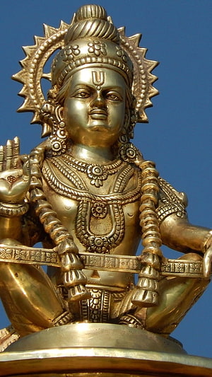 Golden Ayyappan Statue with Intricate Jewelry and Sunburst Halo Against Blue Sky HD phone wallpaper