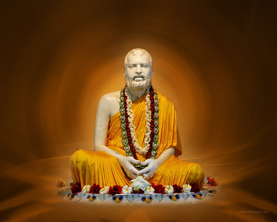 Sri Ramakrishna seated statue in saffron robes with floral garlands and offerings HD wallpaper