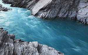 Turbid turquoise glacial river flowing through a rugged rocky gorge HD wallpaper