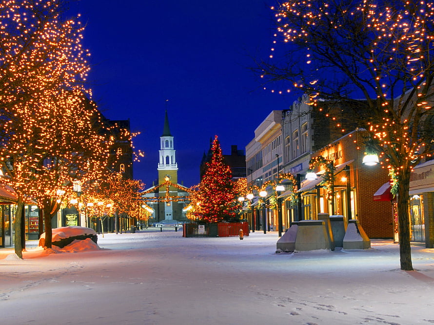 Festive Snow-Covered Town Square at Night with Christmas Tree and Church Steeple HD wallpaper