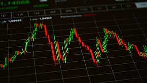 Candlestick Stock Market Chart Displaying Volatile Trading Patterns on a Dark Screen HD wallpaper