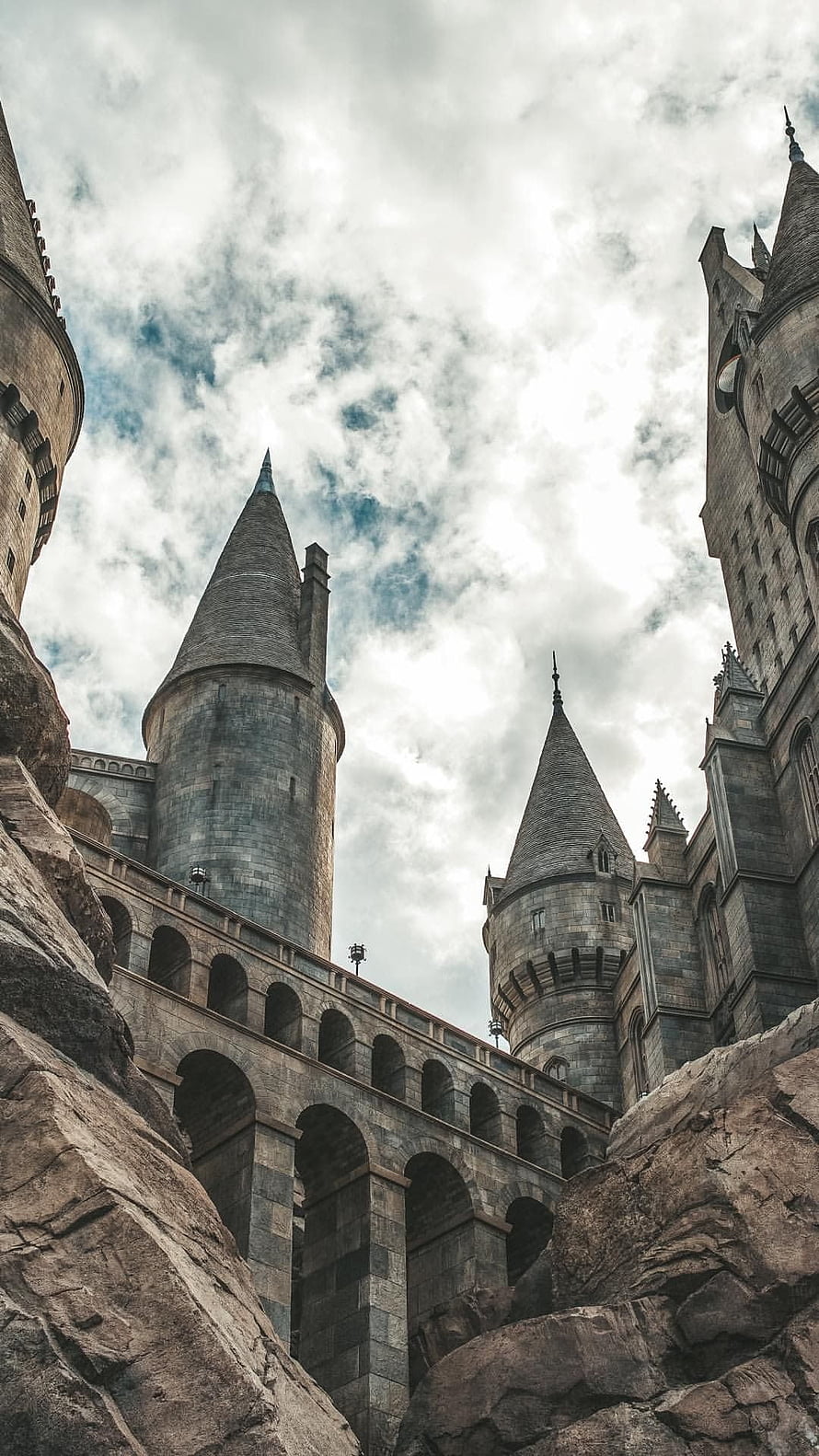 Hogwarts Castle Towers and Arched Bridge Under Cloudy Sky HD phone wallpaper