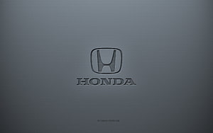 Honda emblem embossed on a smooth gray metallic surface with subtle texture and soft lighting HD wallpaper