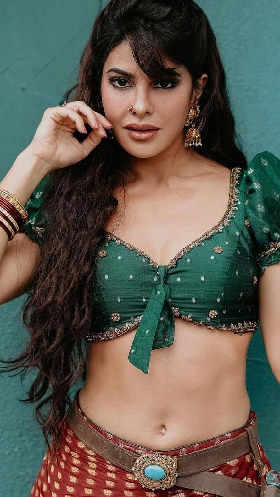 Jacqueline Fernandez in a green embroidered blouse and red skirt with a turquoise belt buckle HD phone wallpaper