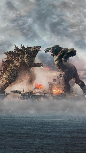 Godzilla and King Kong face off in a massive battle above a naval fleet HD phone wallpaper
