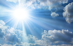 Bright Sunburst Breaking Through Fluffy Cumulus Clouds in a Blue Sky HD wallpaper
